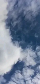 Serene sky with fluffy white clouds on a deep blue background.