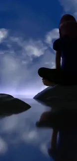 Silhouette against blue sky and clouds reflected in water.