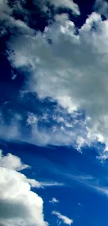 Serene deep blue sky with fluffy white clouds.