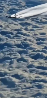 Jet soaring above the clouds in a serene sky.