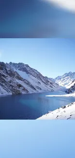 Snowy mountain lake under bright blue sky.