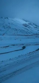 A serene snow-covered mountain lit by icy blue twilight.