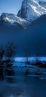 Snowy mountain reflected in a calm blue lake at dawn.