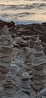 Stacked stone formations by the seaside at sunset.