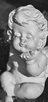 Monochrome stone angel sculpture in a serene garden setting.