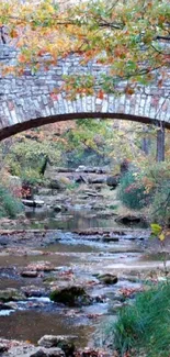 Scenic wallpaper of a stone bridge over a peaceful autumn creek.