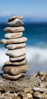 A peaceful stack of stones on a beach with the ocean in the background.