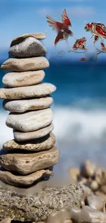 Balanced stones on a beach with blue sky and sea in the background.