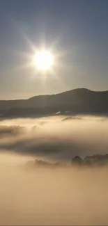 Sunlit mountain landscape with mist and a bright sunrise.