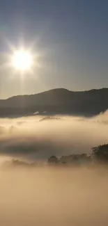 Serene sunrise over misty mountains with sunburst.