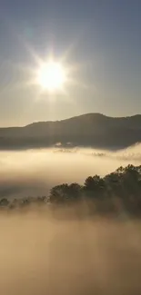 Misty hills at sunrise with sun shining over a serene landscape.