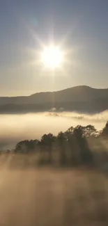 Wallpaper of sunrise over misty hills with sun rays illuminating the scene.