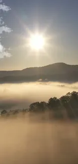 Sunrise over misty mountains with rays streaming through clouds.