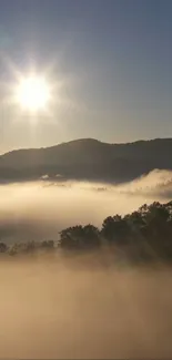 Sunrise over misty mountains with rays shining through the morning fog.