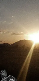 Serene sunset over mountains with angel statue.