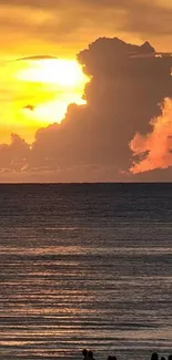 Golden sunset over a tranquil ocean with silhouettes on the beach.