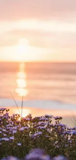 Serene beach sunset with purple wildflowers and ocean waves.