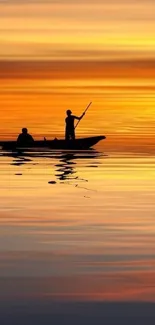 Silhouette of people boating at sunset with golden reflections on water.