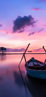 Tranquil sunset with a boat and pink sky reflection on calm waters.