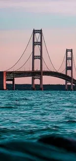 Beautiful bridge over blue ocean at sunset wallpaper.