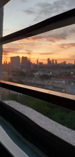 Mobile wallpaper depicting sunset city view through a window frame.