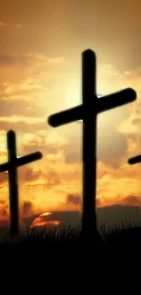 Silhouette of three crosses against a vibrant sunset sky.