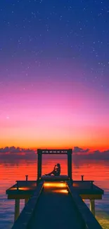 Serene sunset over dock with starry sky.