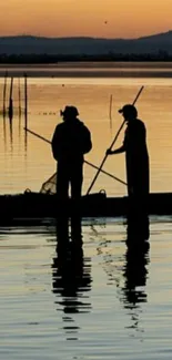 Two fishermen silhouetted against a sunset sky on a calm water surface.