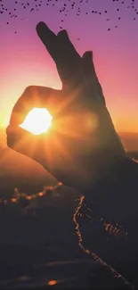 Sunset hand silhouette with a vibrant, purple sky backdrop.