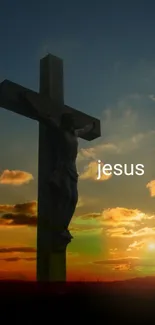 Silhouette of Jesus on cross against a sunset sky.