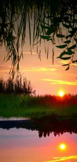 Serene sunset reflecting over a tranquil lake, framed by foliage.