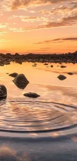 A serene sunset reflection over a tranquil lake with scattered rocks.