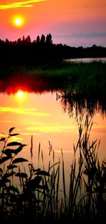 Peaceful sunset reflecting on calm lake waters with vibrant orange hues.