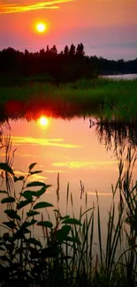 Peaceful sunset over lake with orange reflections and silhouetted trees.