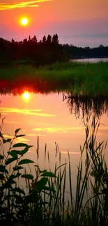 Serene sunset over lake with vibrant reflection and lush greenery.