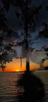 Serene sunset over lake with silhouetted trees.