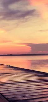 Serene sunset over a tranquil lake with pastel pink and orange sky.