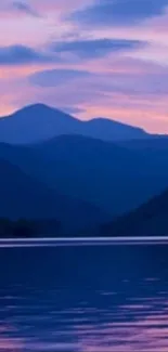 Beautiful sunset over a serene lake with mountains in the background.