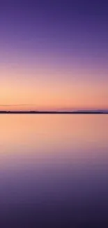 Serene lake at sunset with purple and orange sky.