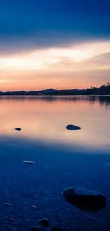 Serene sunset over a tranquil lake with reflections.