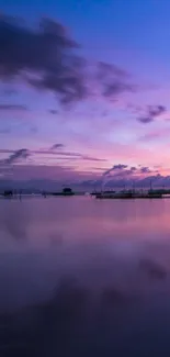 Serene sunset over a lake with a boat and purple sky.