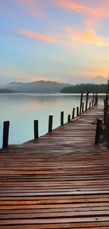 A serene sunset view over a calm lake with a rustic wooden pier.