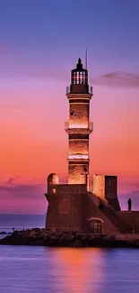 Serene lighthouse at sunset with pink and purple sky over a calm ocean.