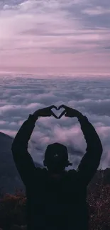 Silhouette forming heart against a purple sunset sky.