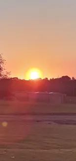 Serene sunset over a peaceful landscape with an orange sky.