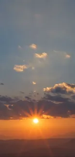 Serene sunset with orange hues, clouds, and mountains.