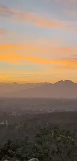 Stunning sunset over mountains with vibrant sky and lush greenery.