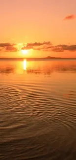 Beautiful orange sunset over calm ocean waters creating a serene and tranquil scene.