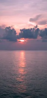 Serene sunset over ocean with cloudy sky.