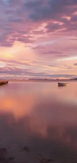 A tranquil sunset with a pastel pink sky reflecting on calm waters.